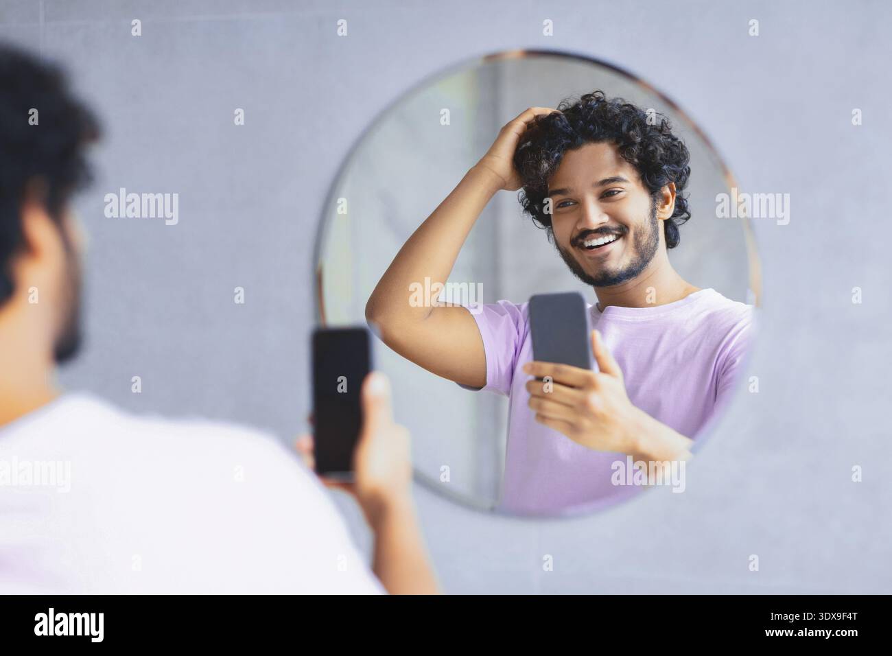 Man Taking Selfie While Looking in Mirror and Smiling During Morning Routine Stock Photo