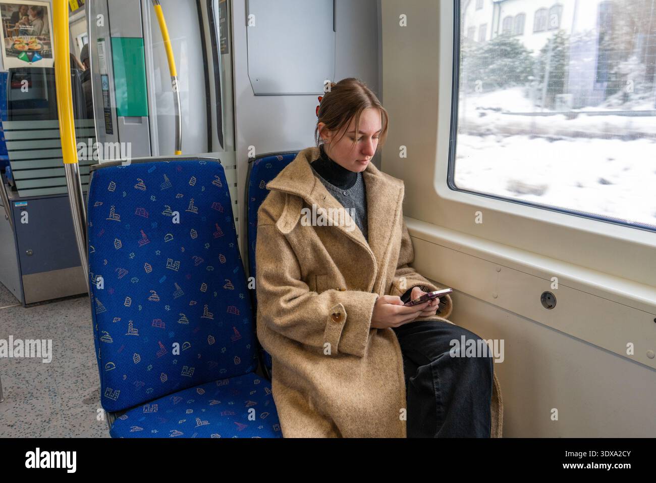 Young Woman Working Remotely on Train During Winter Travel.  Stock Photo