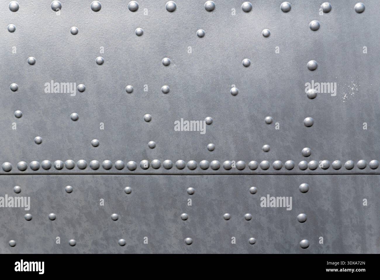 A close view of a metal surface showing rows of rivets and patterned ...