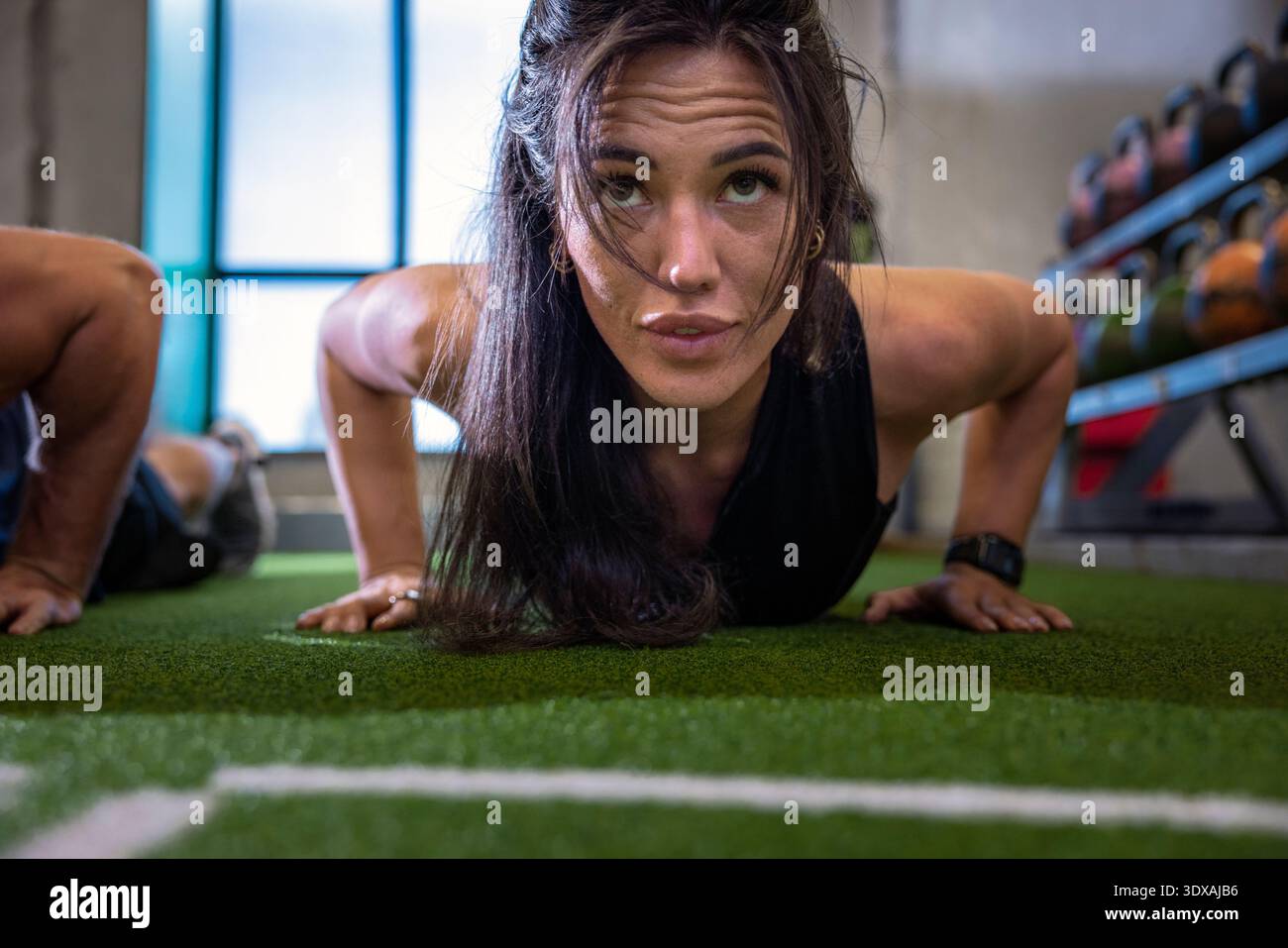 Woman doing push ups in gym Stock Photo