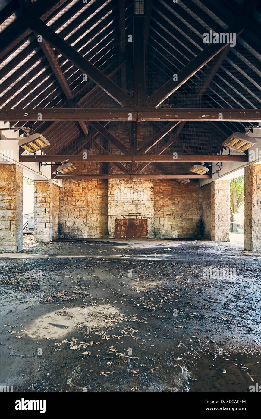 Dirty Rafters Rustic stone shelter interior with exposed timber roof rafters and a ...