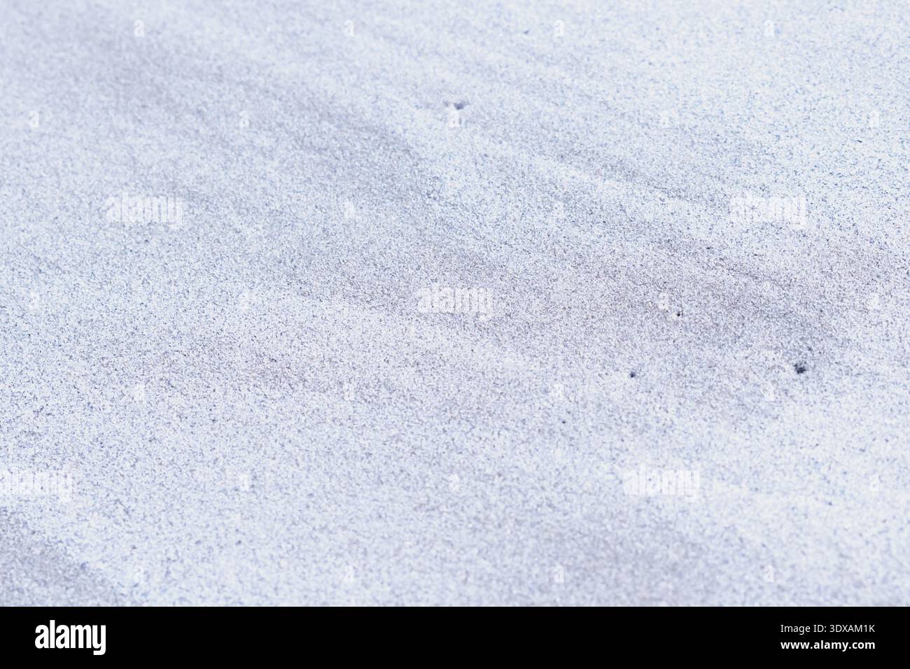 Wind patterns on grey sand surface creating textured background in natural environment Stock Photo