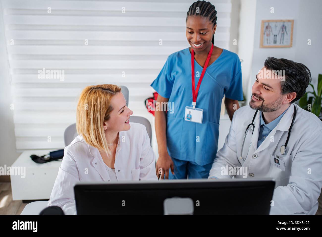 Medical professionals collaborating on computer in clinic office Stock Photo