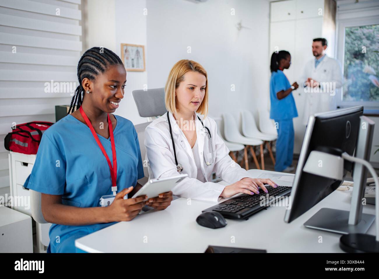 Medical professionals collaborating on computer in clinic office Stock Photo