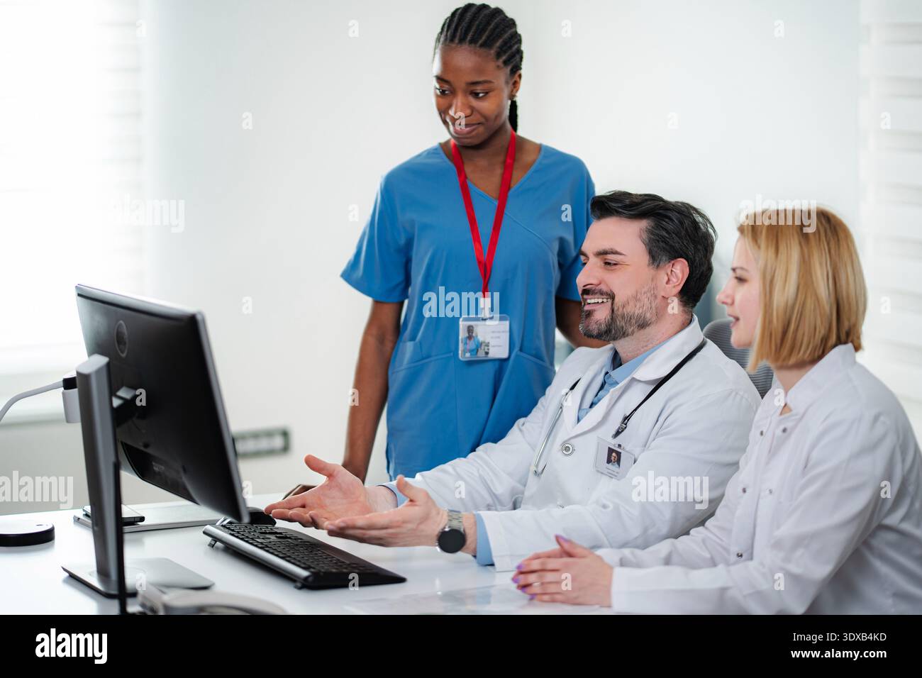 Medical team collaborating on computer in clinic office Stock Photo - Alamy