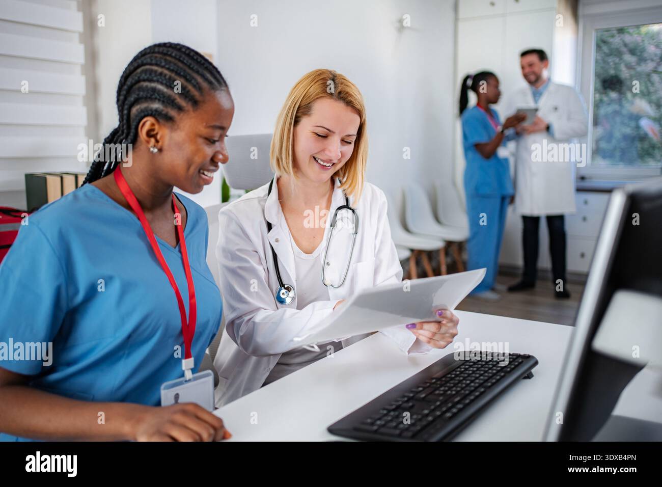 Medical professionals collaborating on documents in clinic office Stock Photo
