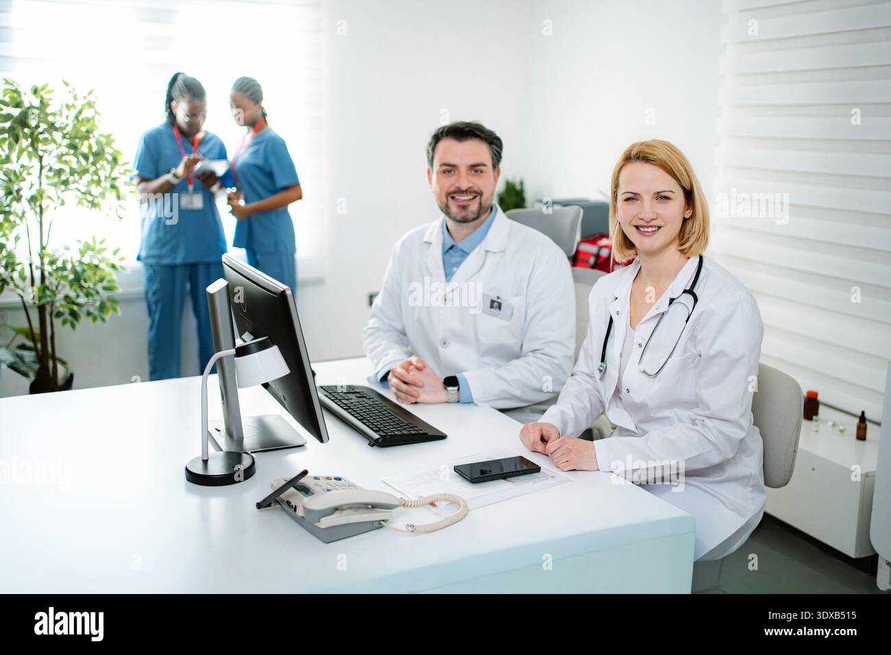 Medical professionals smiling in modern clinic office Stock Photo