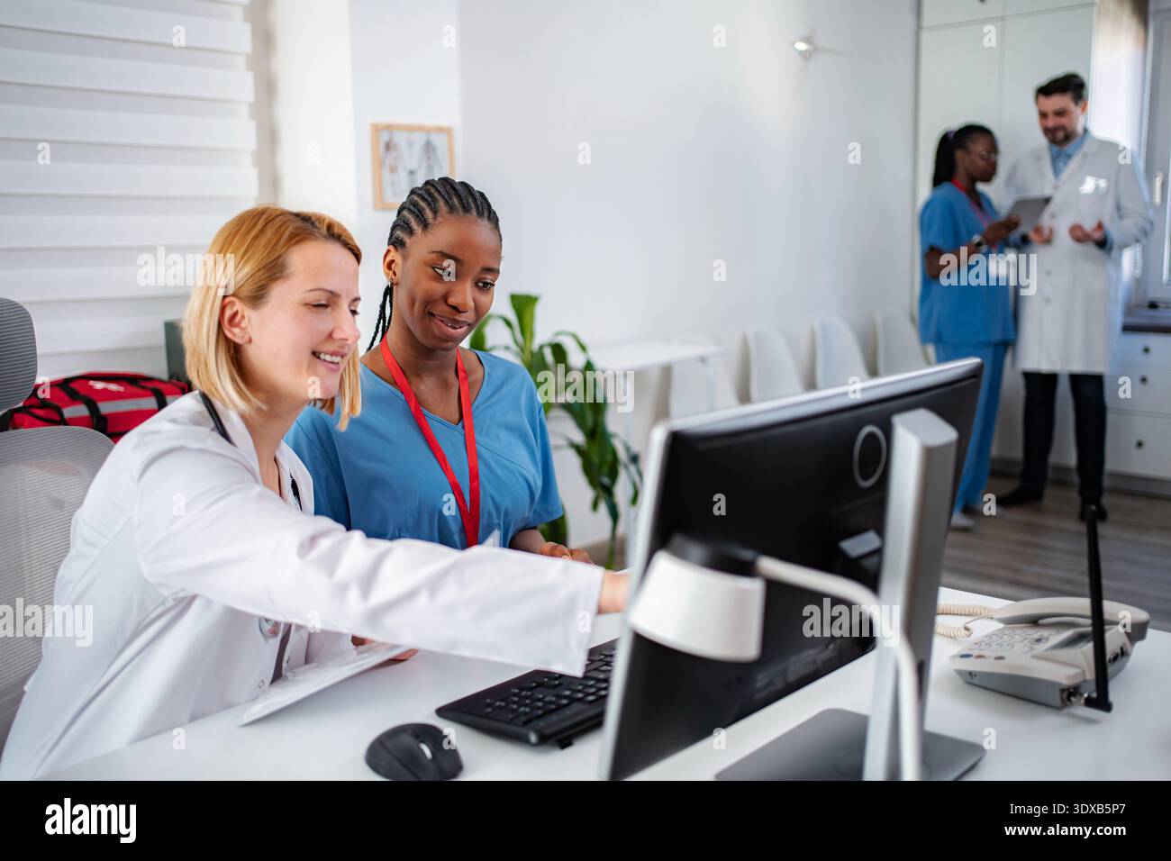 Medical professionals collaborating on computer in clinic office Stock Photo