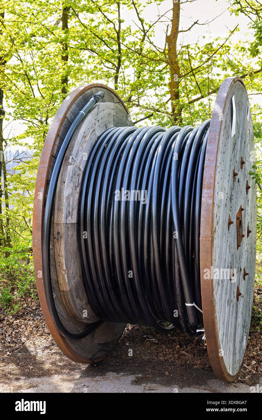 large wooden drum, fitted with black conduit for cable routing, germany ...