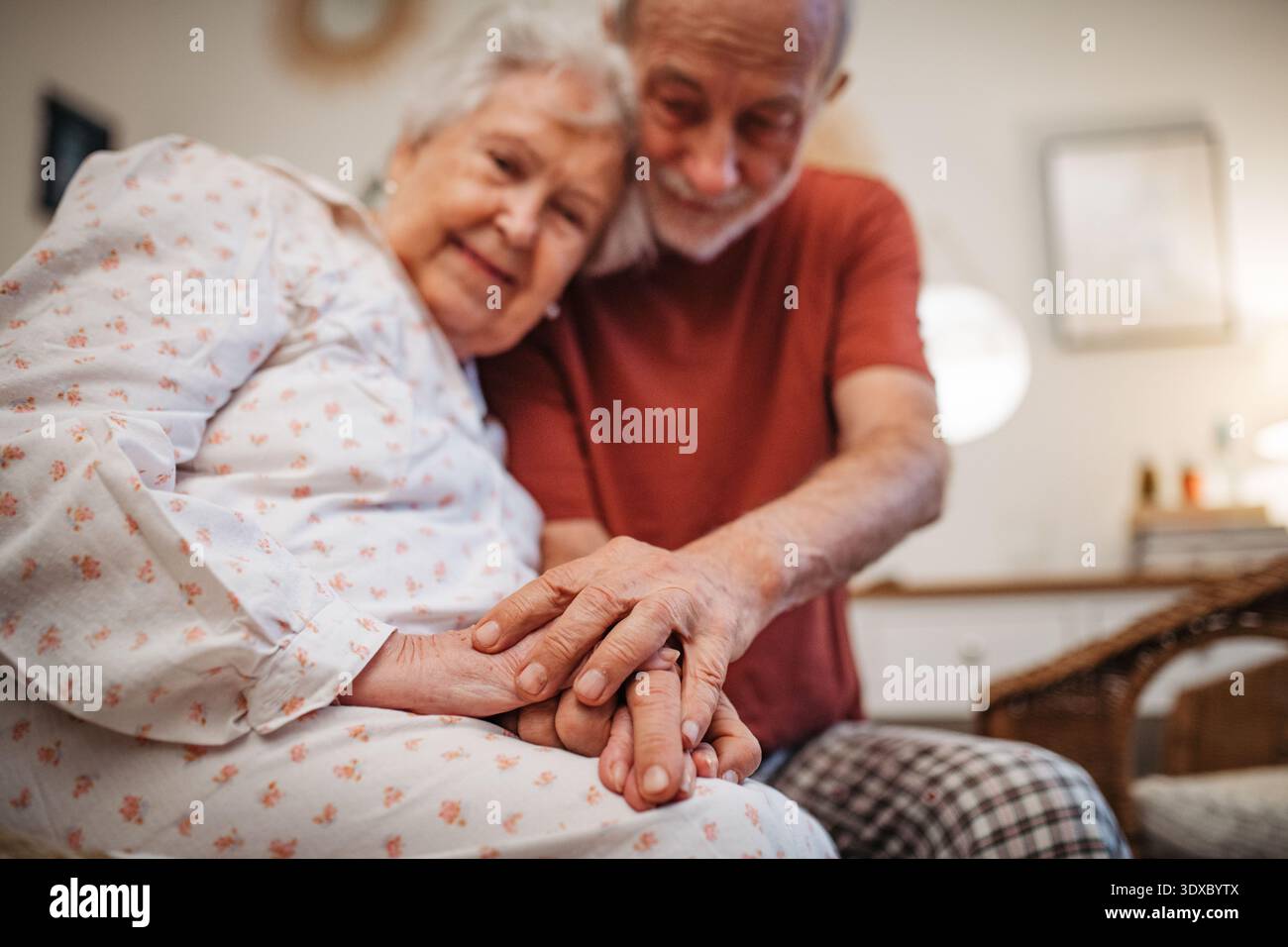 Elderly spouses sharing quiet moment before sleep. Stock Photo
