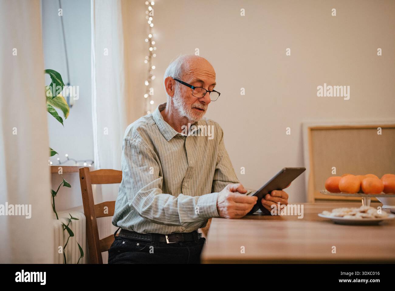 Elderly man using tablet, shopping online. Stock Photo