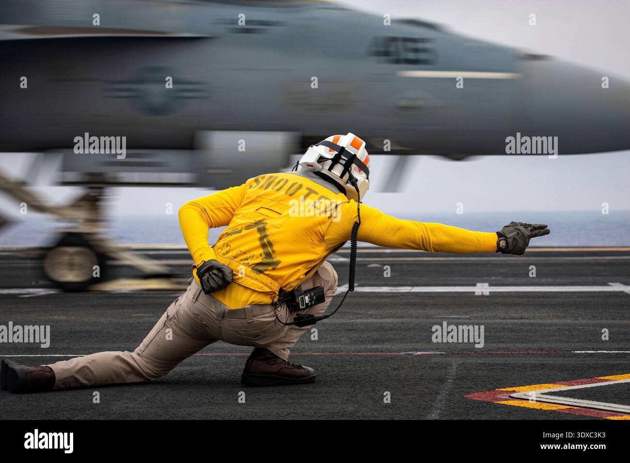 Lt. Tom Sandford, assigned to Air Department aboard the world's largest aircraft carrier, USS Gerald R. Ford, signals the launch of a Carrier Air Wing 8 F/A-18E Super Hornet attached to Strike Fighter Squadron 87 on the flight deck, 15 August 2025.  Gerald R. Ford, a first-in-class aircraft carrier and deployed flagship of Carrier Strike Group Twelve, is on a scheduled deployment in the U.S. 6th Fleet area of operations to support the effectiveness, lethality and readiness of U.S. forcesEditorial Use Only. Not for Endorsement. Credit: (U.S. Navy / Petty Officer 2nd Class Mariano Lopez. Stock Photo