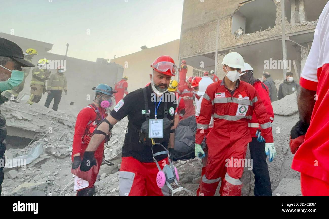 An Iranian Red Crescent rescue team carries an injured person from a ...