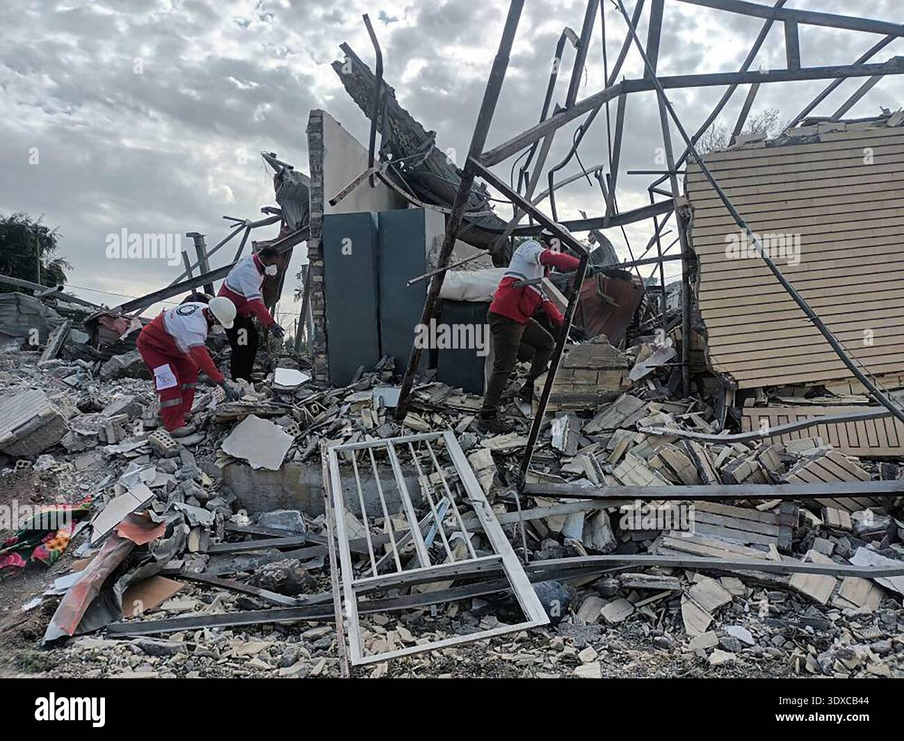 Members of Iranian rescue teams search through the rubble for victims ...