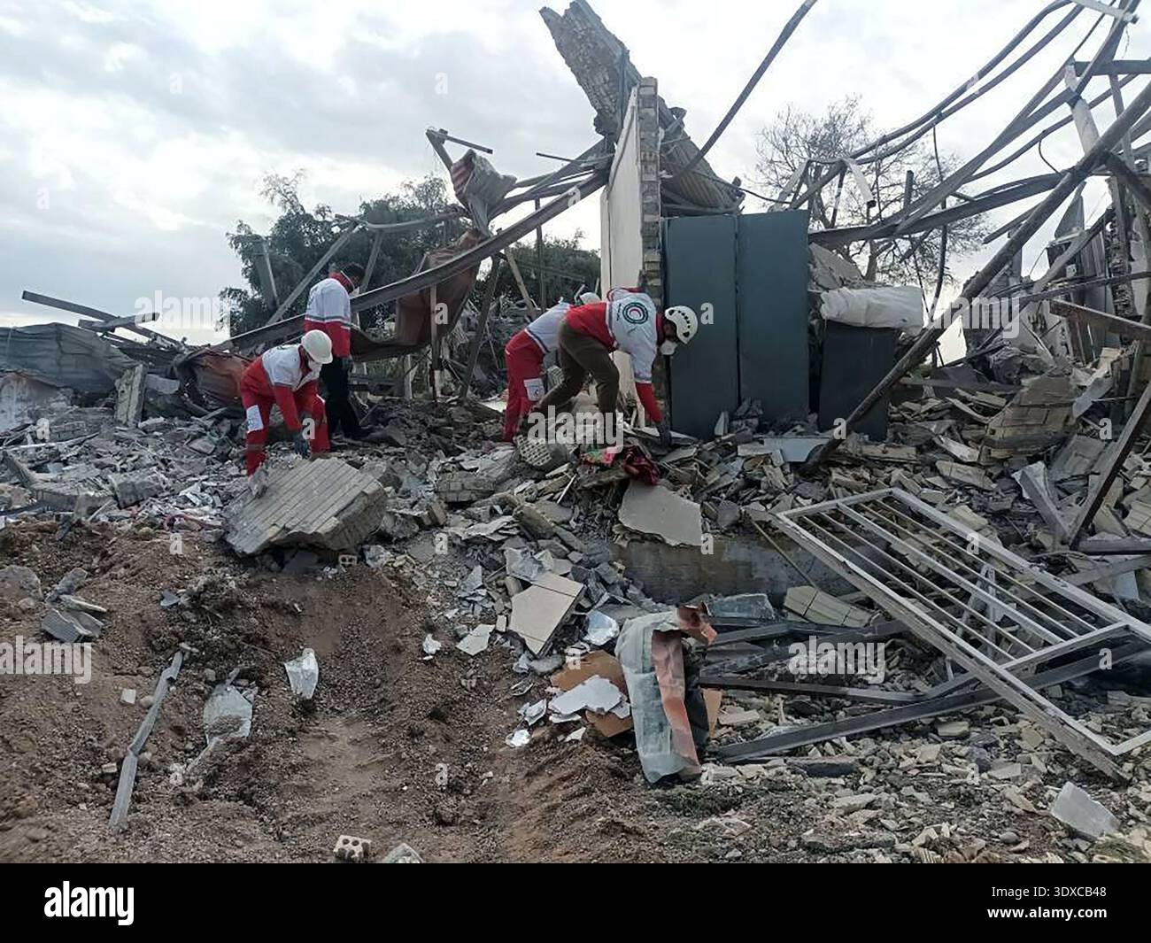Members of Iranian rescue teams search through the rubble for victims ...