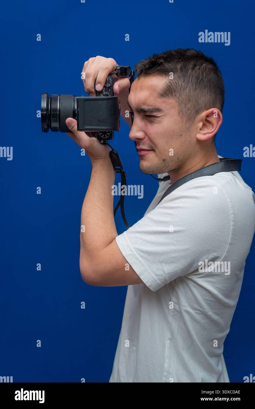 Photographer holding a camera and focusing on a subject, demonstrating skill and passion for visual storytelling and imaging Stock Photo