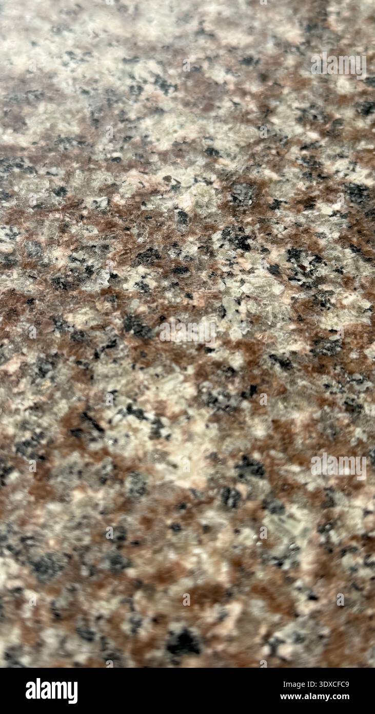 Granite texture with a mix of brown, black, and white speckles, suitable for background use. Mobile photo Stock Photo