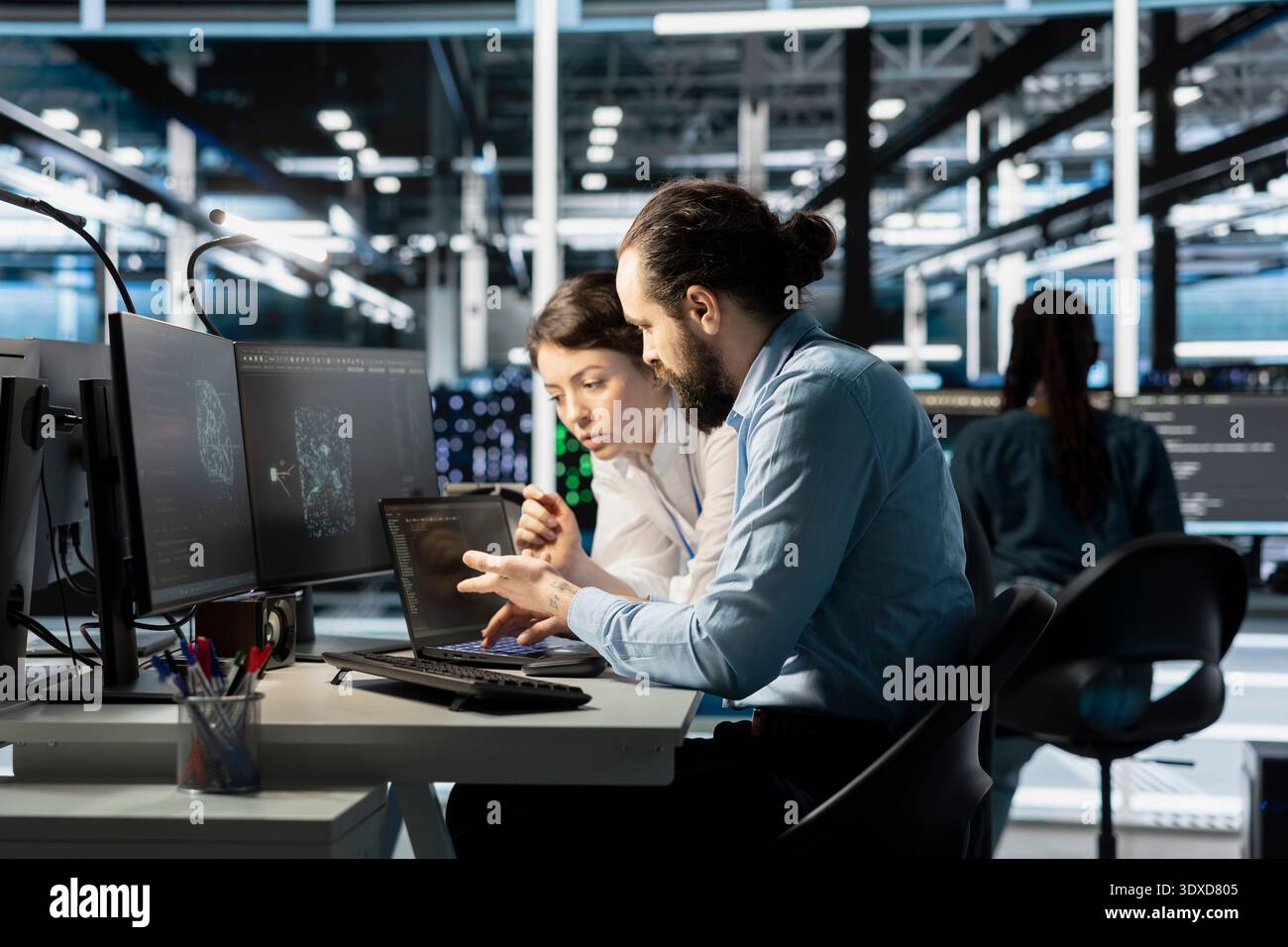 Team of software developers in data center integrating AI driven automation tools. Server farm IT professionals doing brainstorming, using artificial intelligence deep learning models Stock Photo