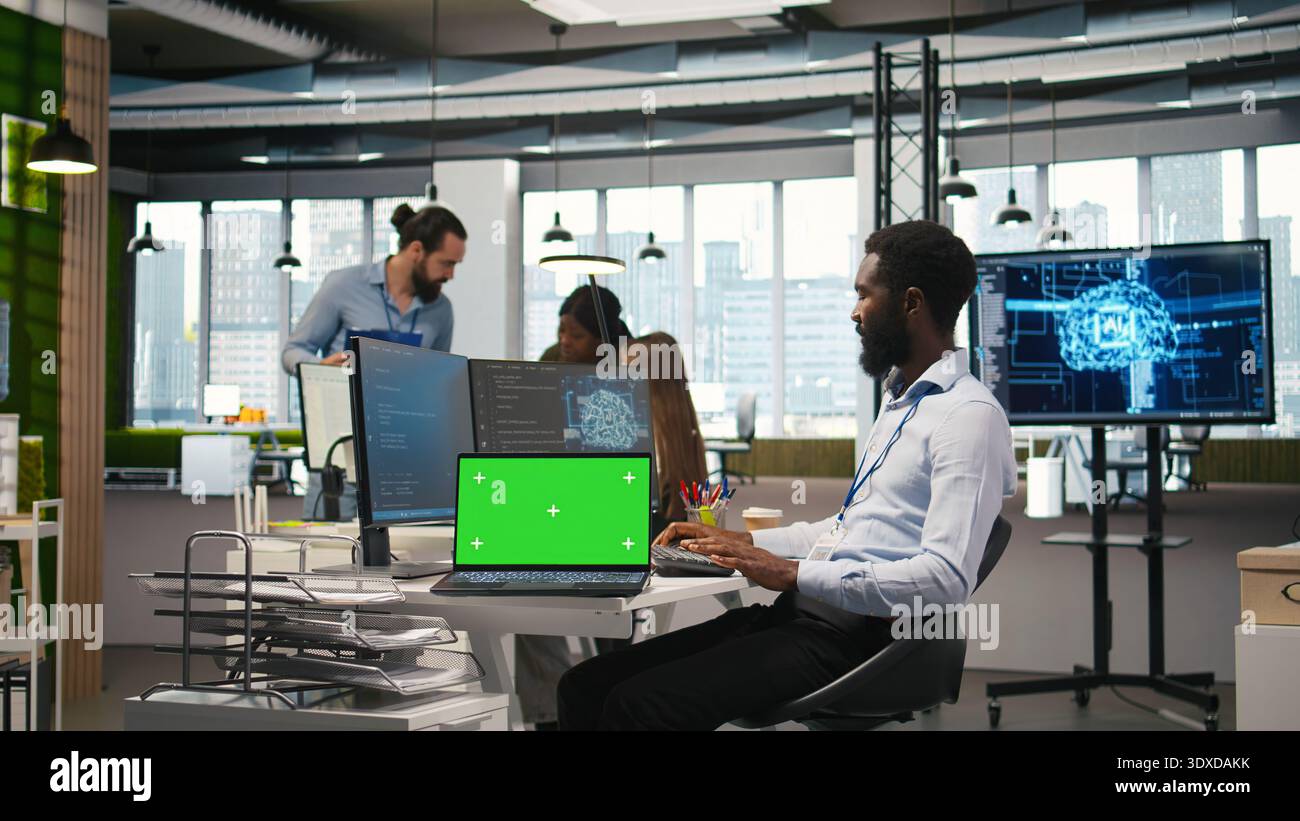 Startup office programmer using green screen laptop, developing artificial intelligence models for business analytics. IT expert using mockup notebook, running simulations for AI forecasting, camera A Stock Photo