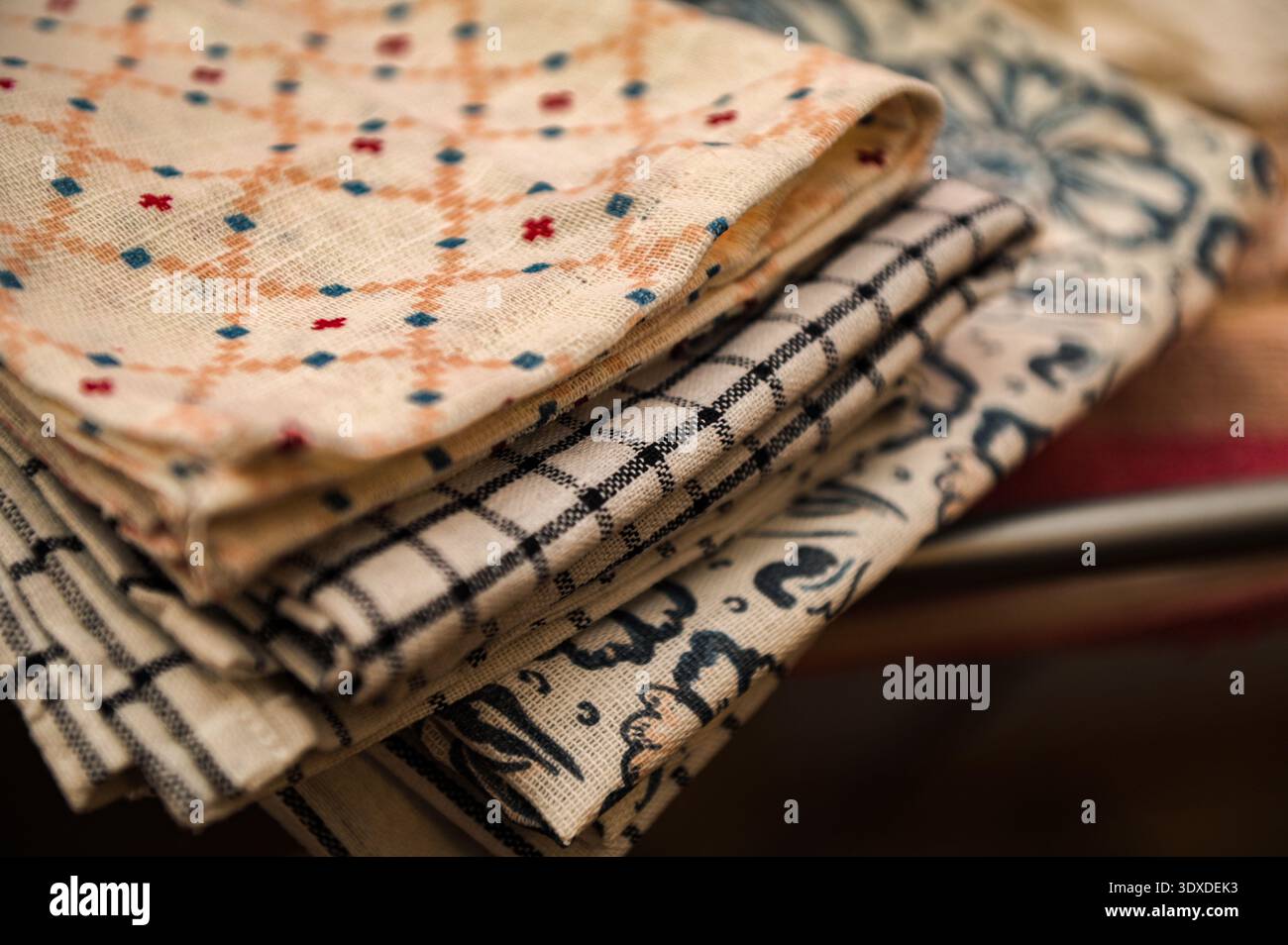 Clean linen towels on the kitchen table, selective focus.Folded kitchen towels. Stock Photo