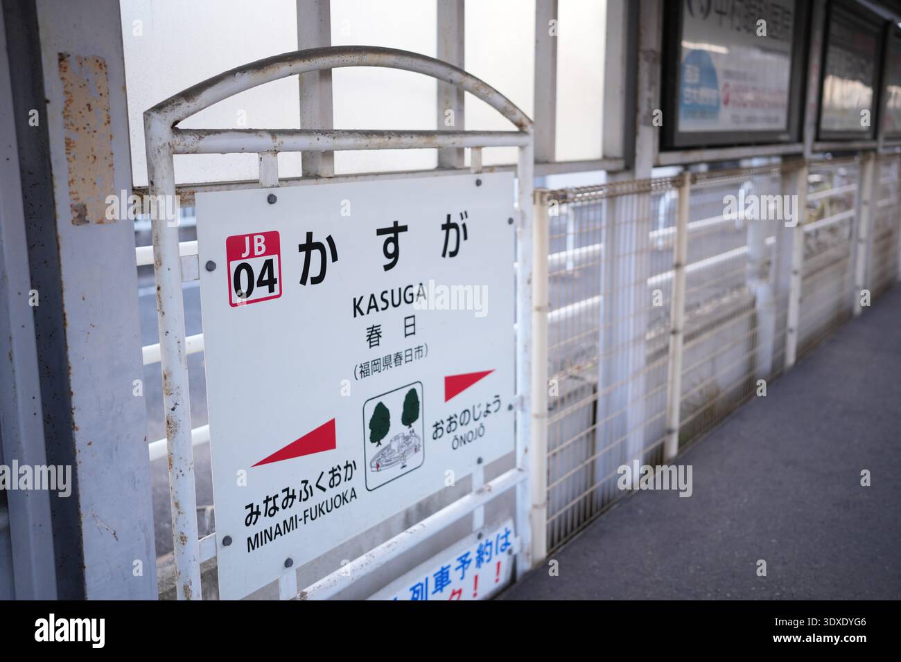 Station sign shows Japanese train station name. Simple white sign