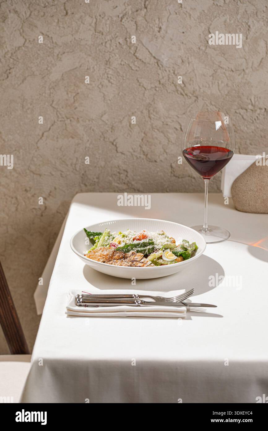 Caesar salad with grilled chicken and wine Stock Photo