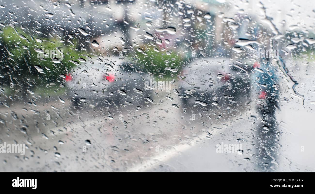 Raindrops on windshield from inside the car in traffic jam. Stock Photo
