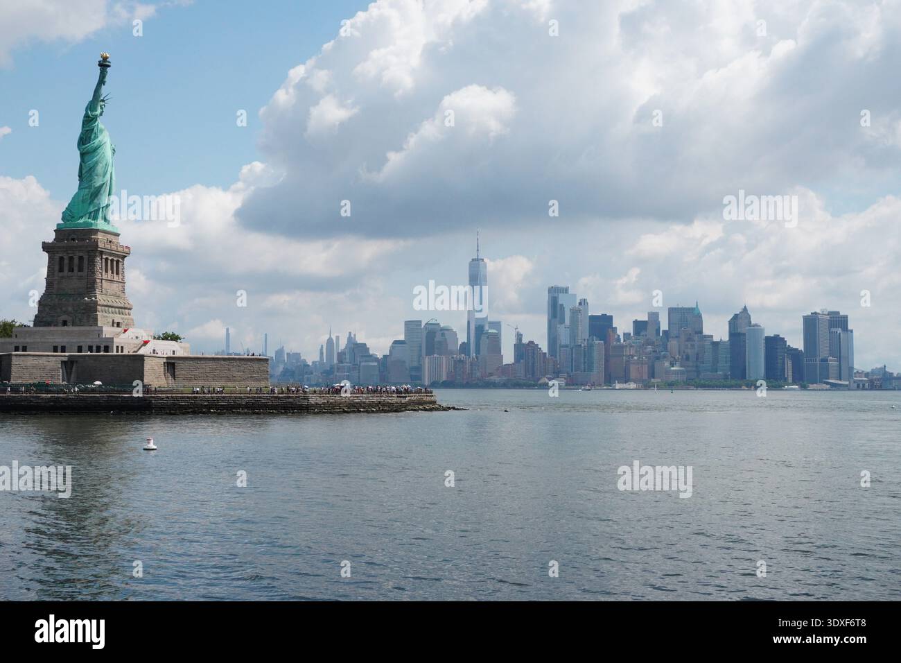 Statue of Liberty and the Manhattan skyline with One World Trade Center across New York Harbor Stock Photo