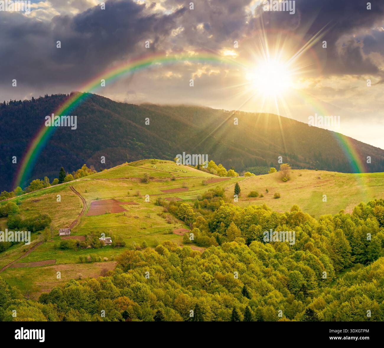 rural mountain landscape during spring at sunset. wonderful countryside scenery on a cold weather in evening light. cloudy sky above rolling hills in Stock Photo