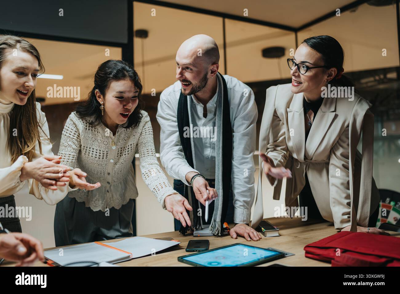 Business team brainstorms ideas during a collaborative meeting around a table Stock Photo