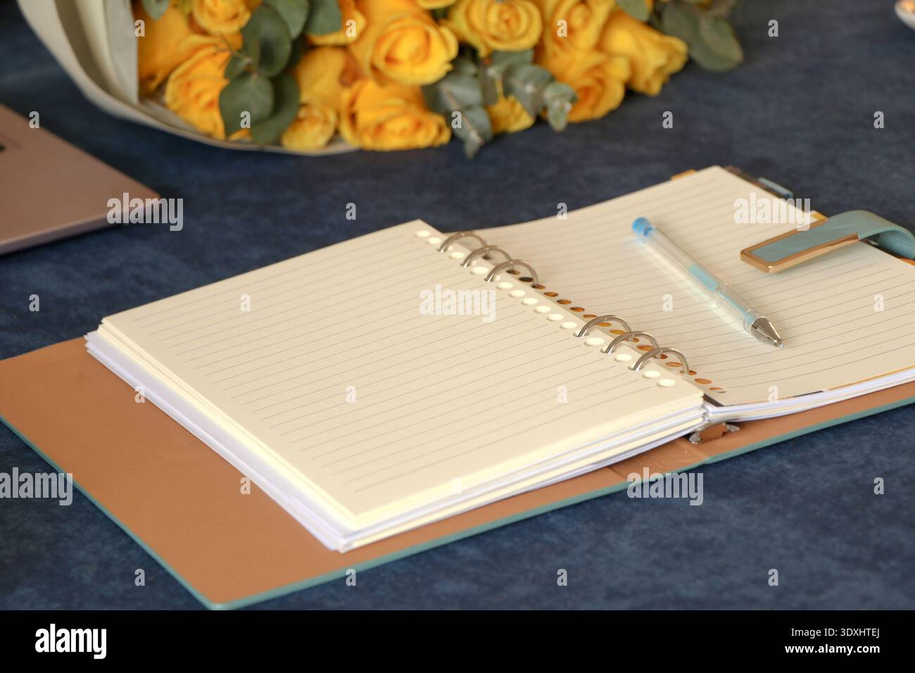 Year Planning Concept with Open Spiral Notebook, Pen, Coffee Cup on Blue Desk Stock Photo