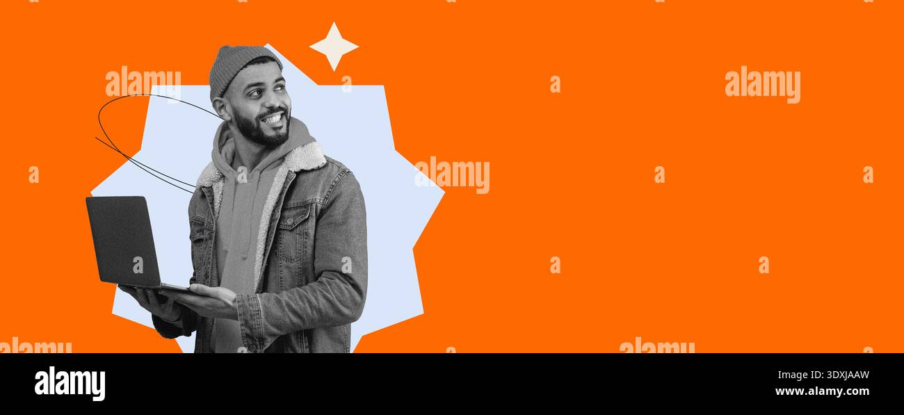 Young Man Using Laptop While Smiling in a Bright Orange Background Stock Photo