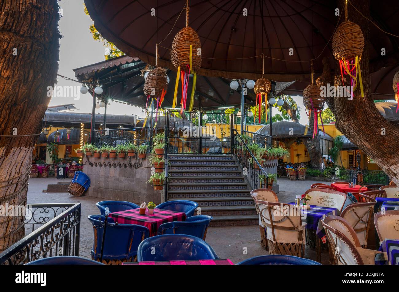 Interior view of El Parian in Tlaquepaque Jalisco Mexico featuring traditional kiosk, colorful tables and authentic Mexican restaurant atmosphere. Ico Stock Photo
