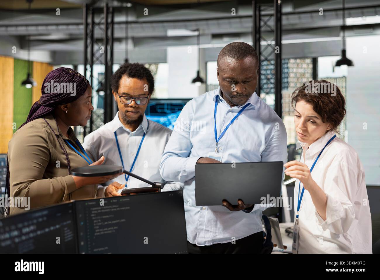 Engineering team in artificial intelligence tech company workplace conducts code reviews. Teamworking colleagues using application in office to design and implement machine learning algorithms Stock Photo