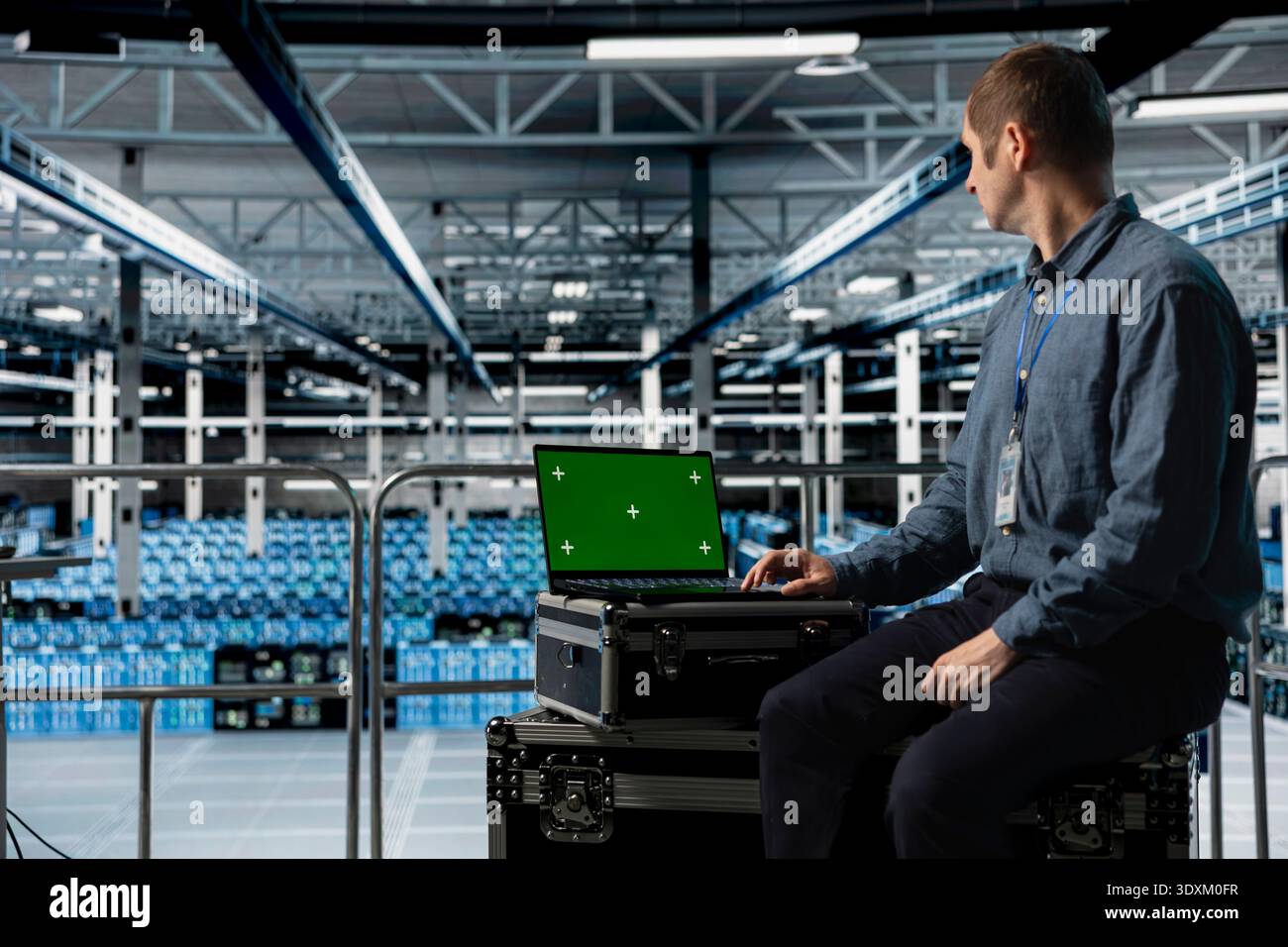 Data center employee using green screen notebook, minimizing downtime through predictive maintenance. Engineer using mockup laptop in server hub, implementing sustainable energy efficient technologies Stock Photo