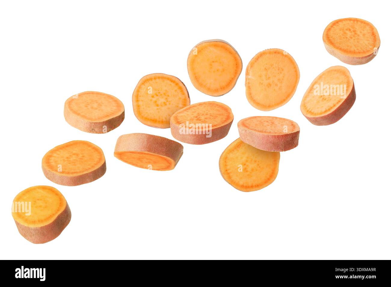 Sweet potato pieces falling against white background Stock Photo