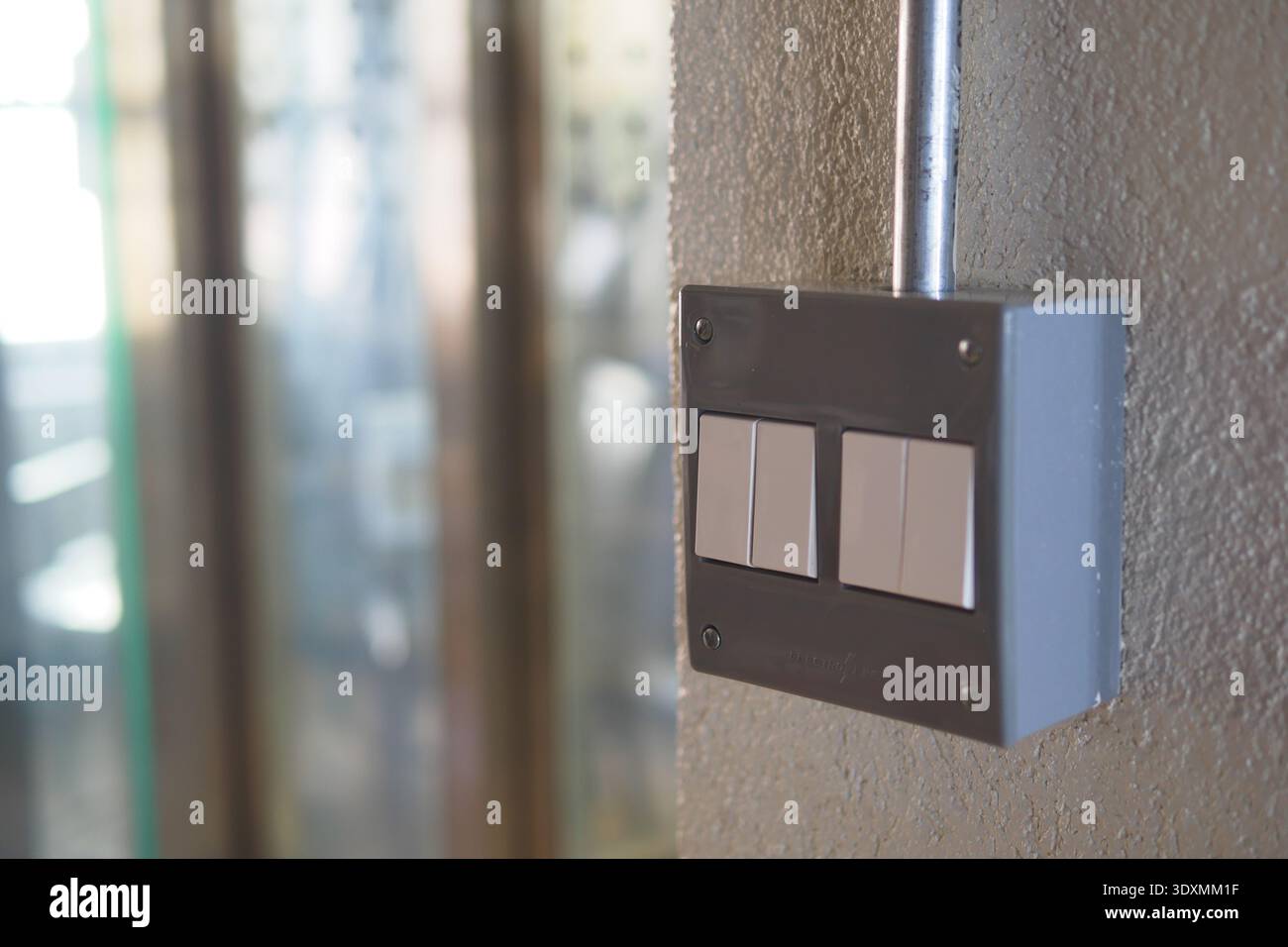 Light switch mounted on a wall in a building corridor Stock Photo