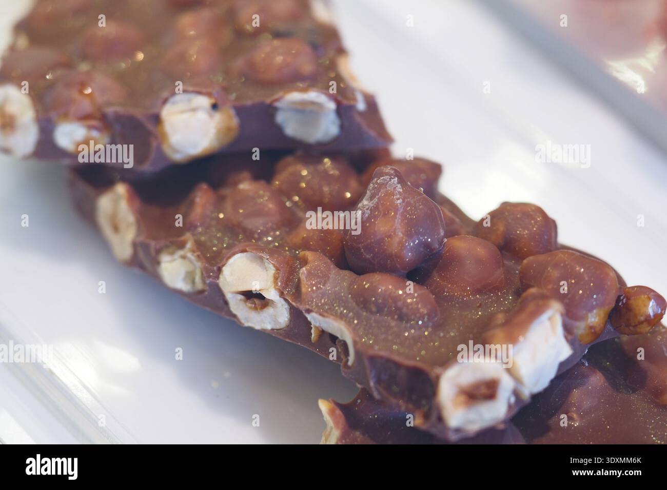 Chocolate bar with nuts on a white plate Stock Photo