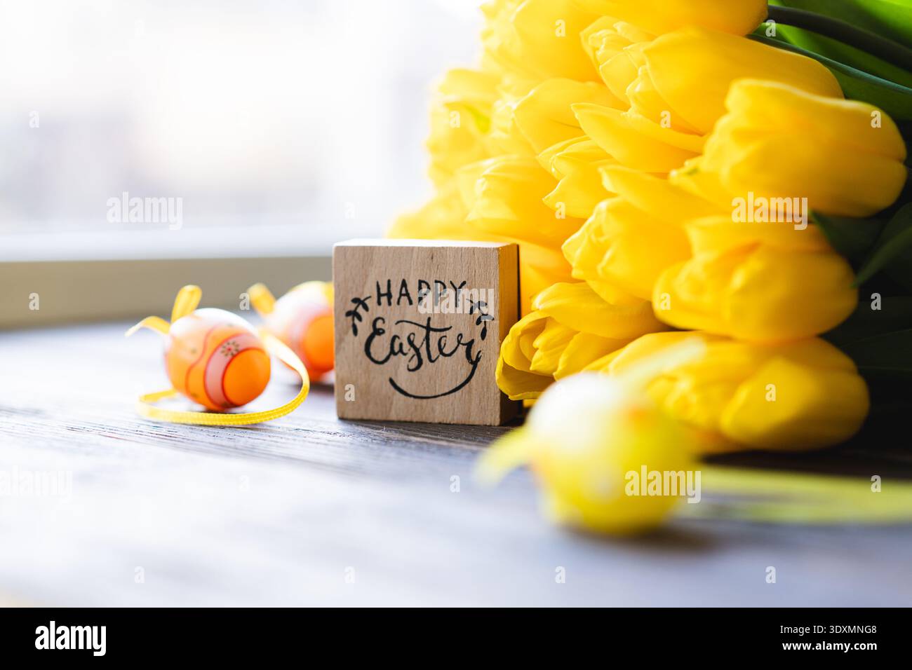 Spring festive composition with yellow tulips and decorative eggs Stock Photo