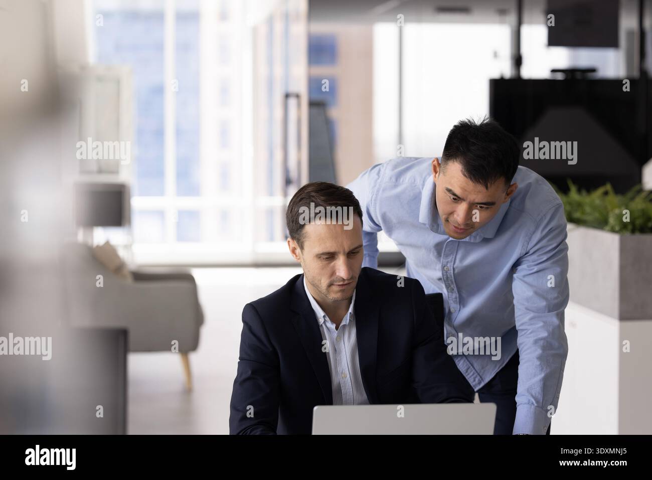 Diverse colleagues team leader worker using laptop at workplace desk Stock Photo