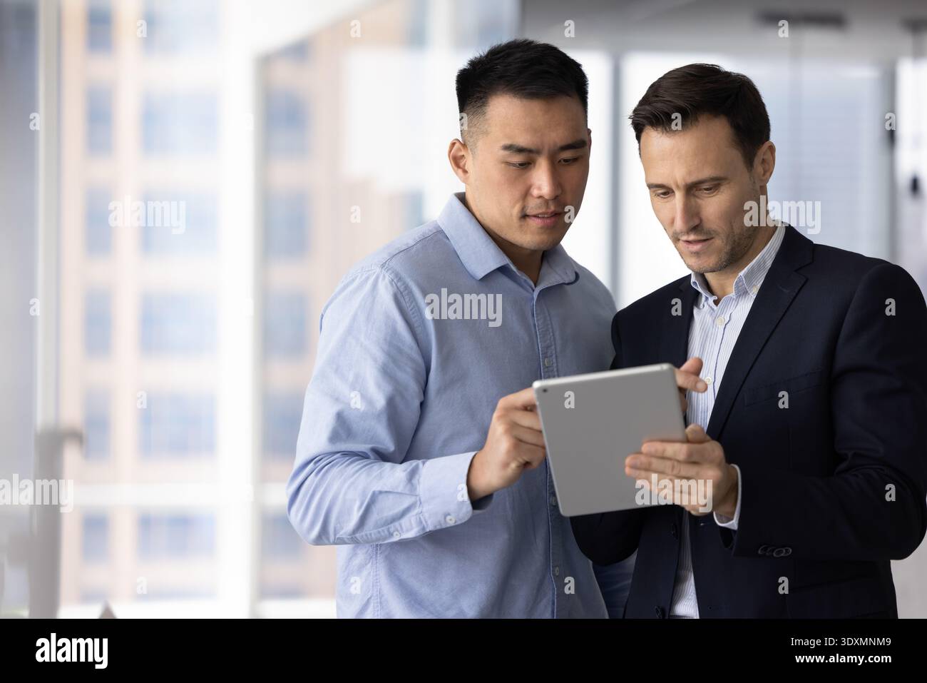 Multiethnic team two business professionals using digital tablet in office Stock Photo