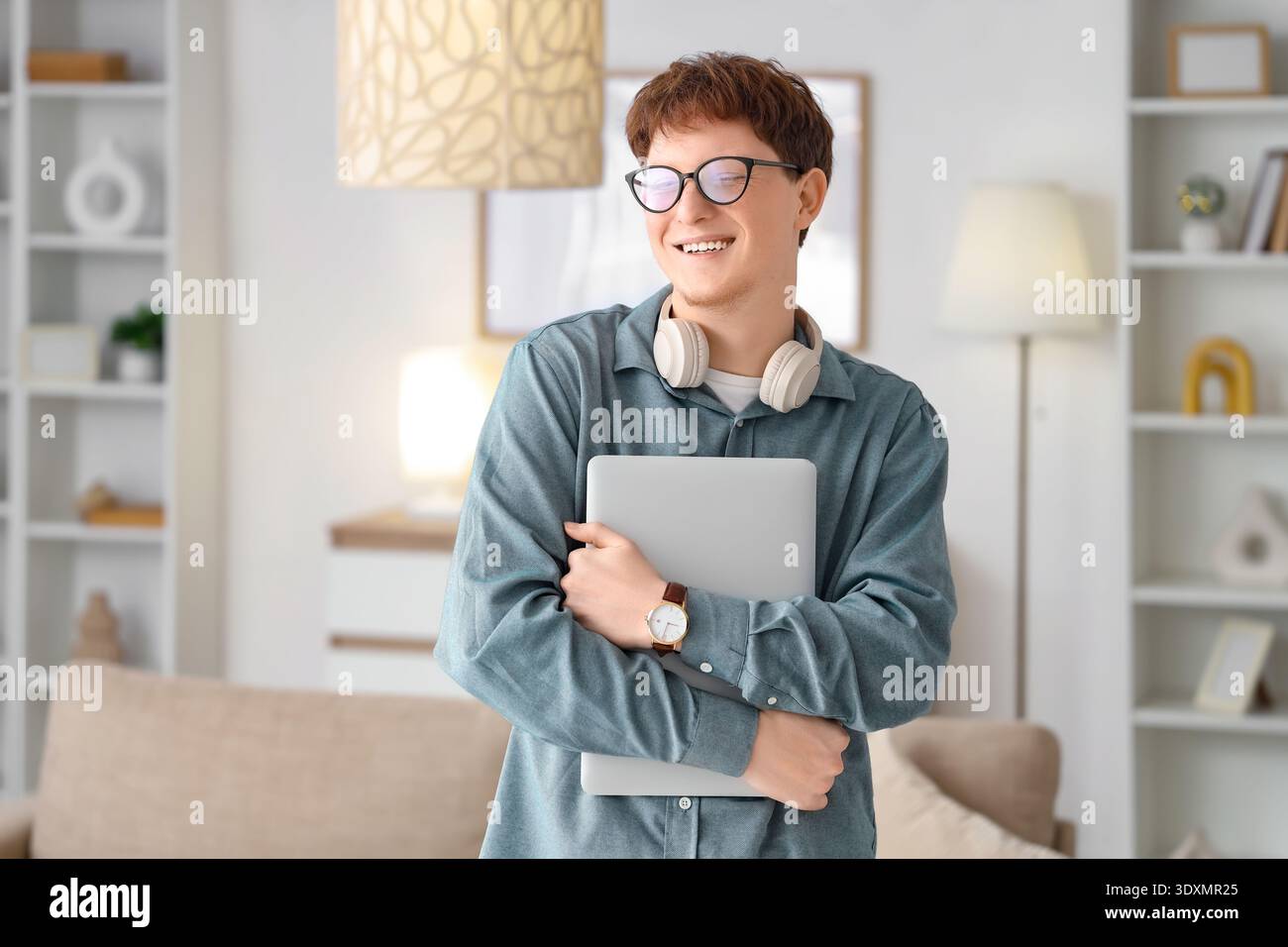 Young man in eyeglasses with laptop at home Stock Photo