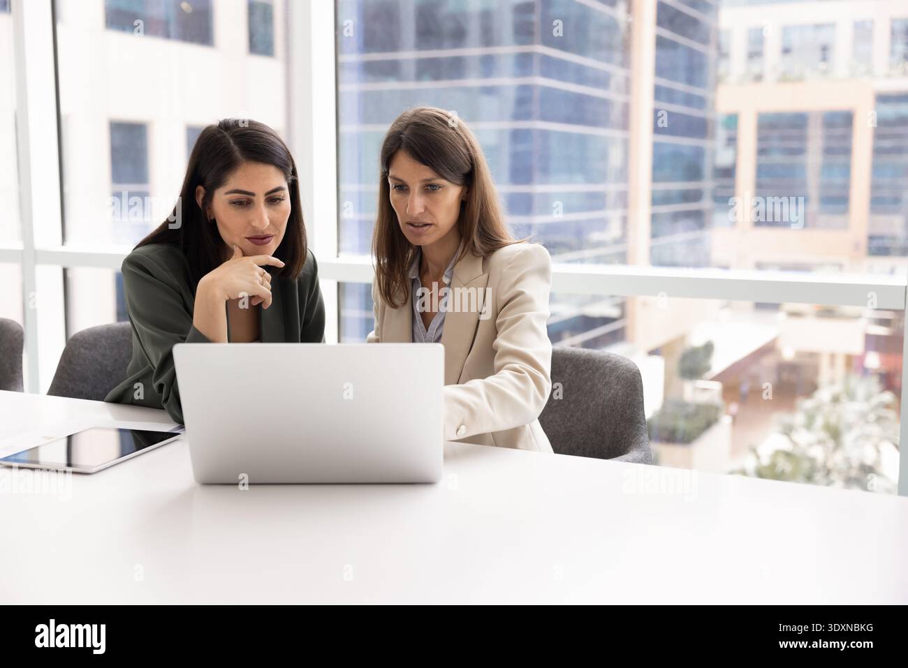 Two professional women analyzing important information on laptop Stock Photo