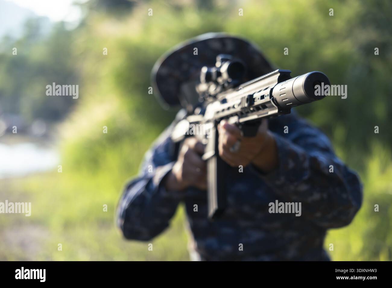 Focused soldier in camouflage uniform aiming tactical assault rifle ...