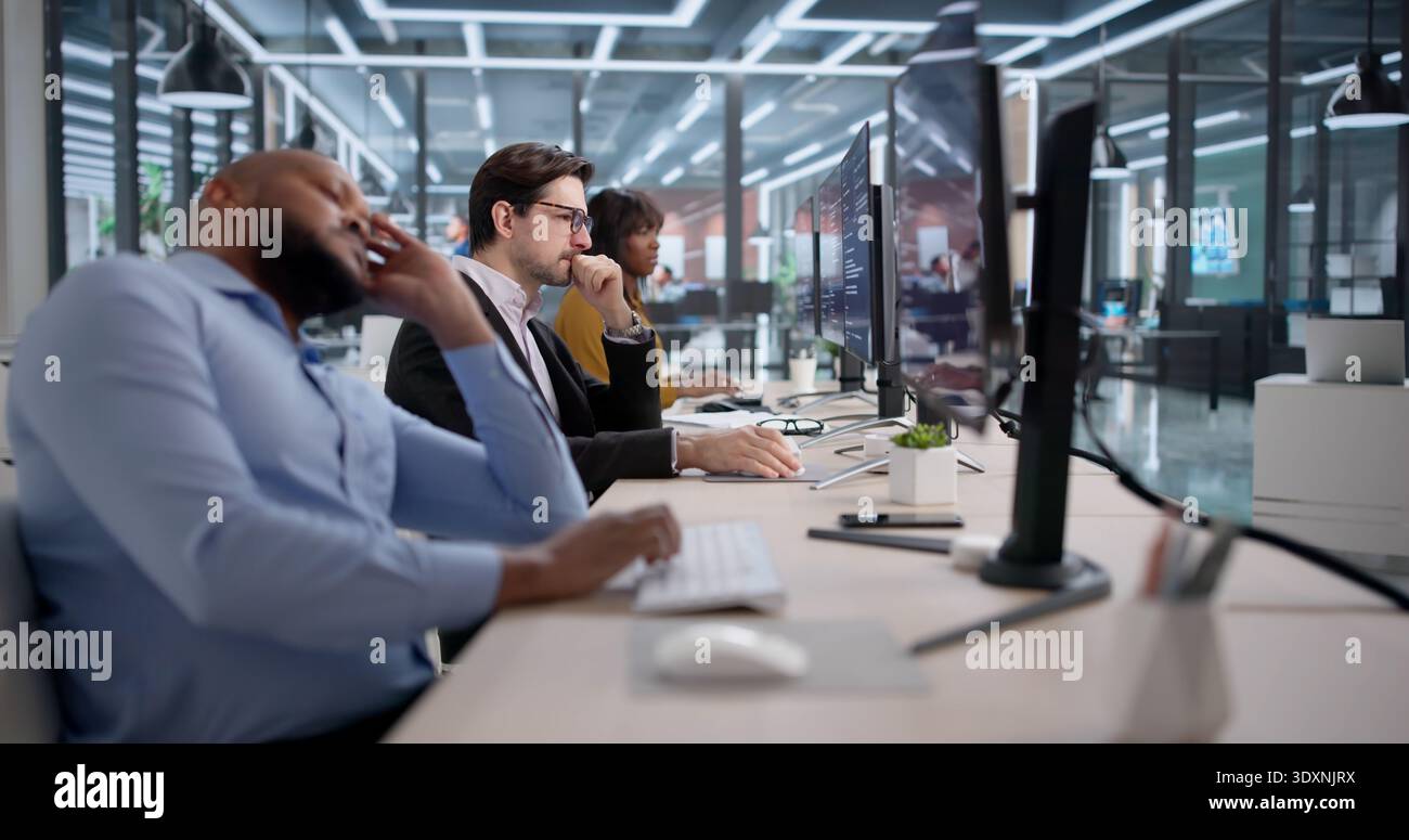Frustrated Software Developer Reviews Broken Code At Their Messy Office Desk. An Unhappy Programmer Struggles Stock Photo