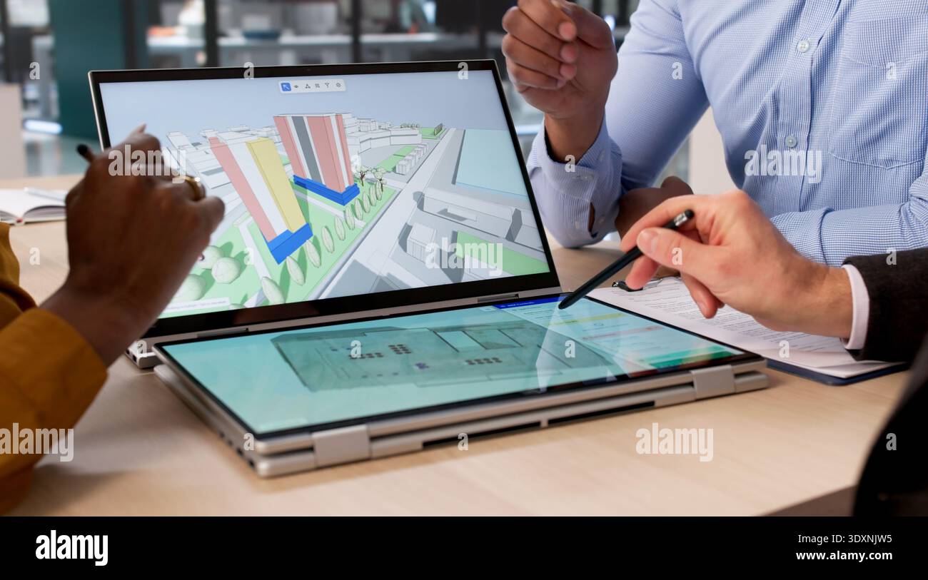 Diverse Group Of Engineers And Architects Use Digital BIM Software To Map Real Estate Sites On Tablets And Laptops Stock Photo