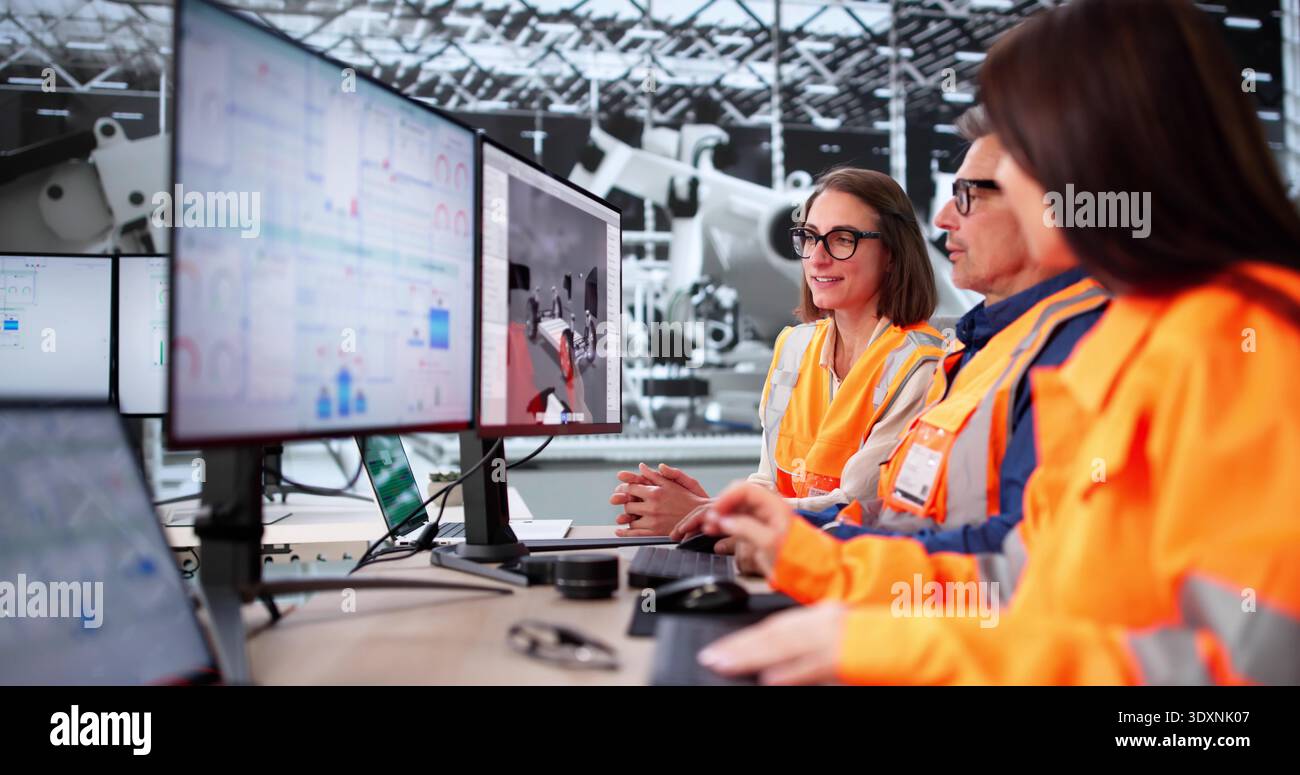 Senior Engineer And Technician Using Advanced PC Technology In Factory. Stock Photo