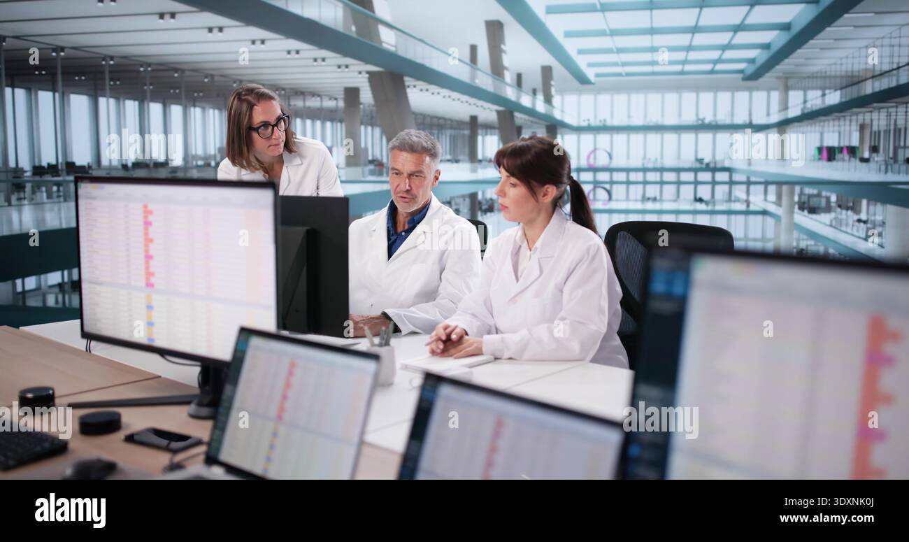 Medical Team Analyzing Billing Codes On Computer In Hospital Setting. Stock Photo