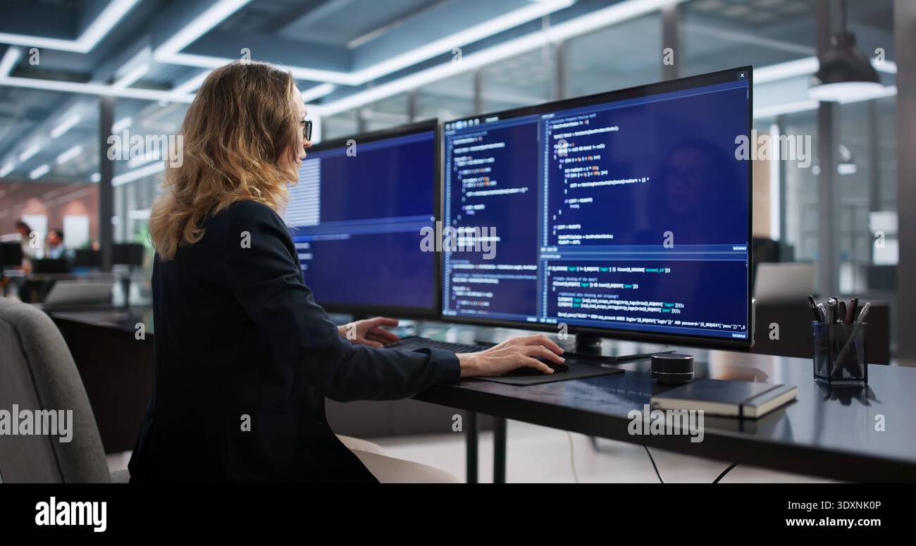 Female Software Engineer Developing Back-end Programs In Secure Office Environment. Stock Photo