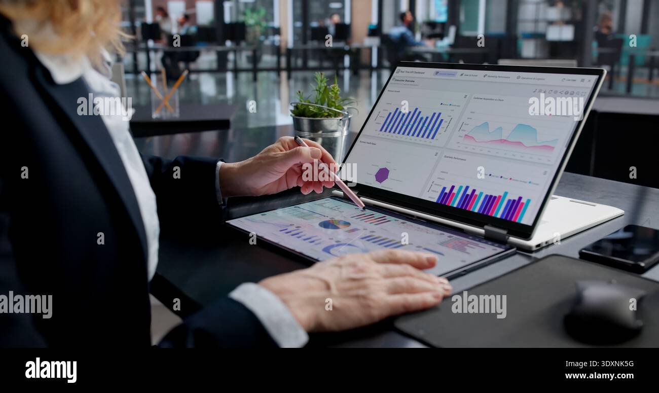 Female Financial Analyst Analyzing KPI Data On Laptop Screen Stock Photo